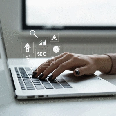 Une main tapant sur un clavier d'ordinateur portable avec des ic&ocirc;nes de SEO flottant au-dessus, &eacute;voquant l'efficacit&eacute; de l'optimisation de contenu avec les LLM